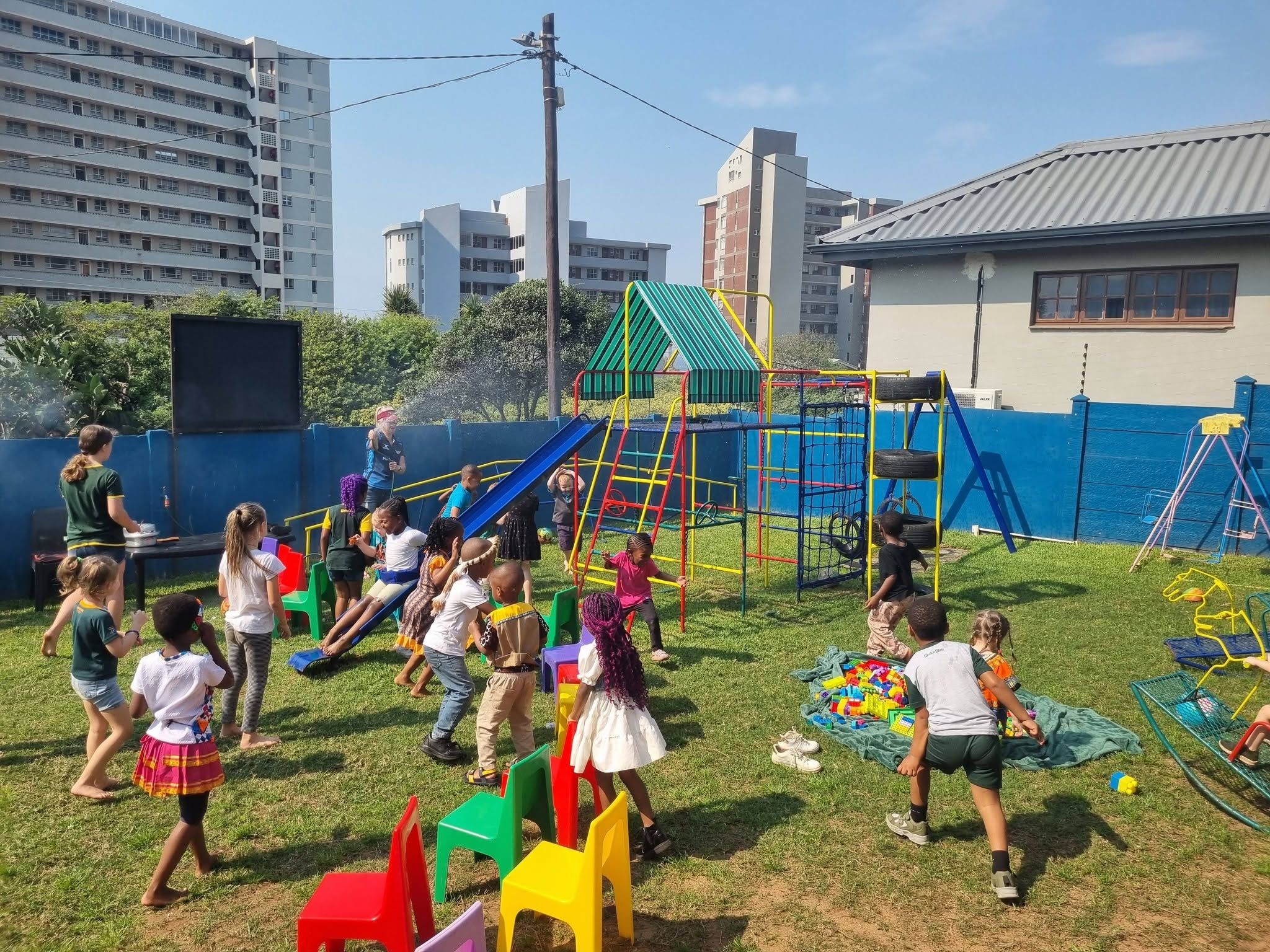 Children playing on the slide and climbing frame in the Emojis playground